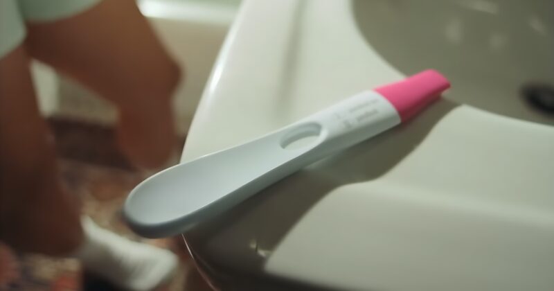 Woman in a bathroom taking pregnancy test